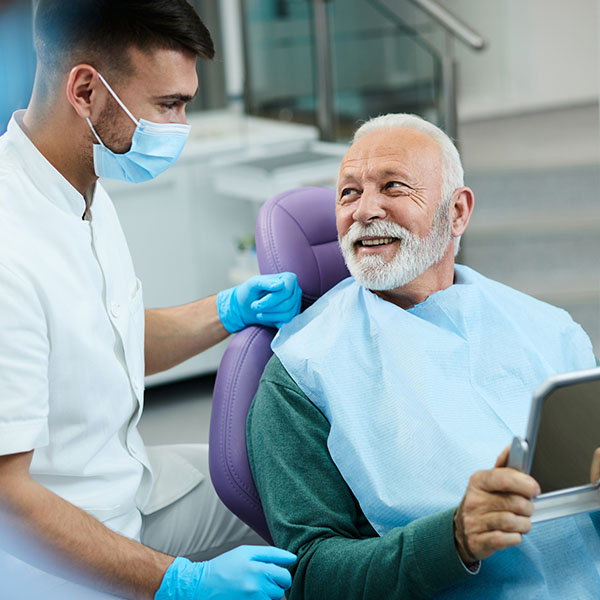 senior man talking to his dentist while being satisfied with dental procedure