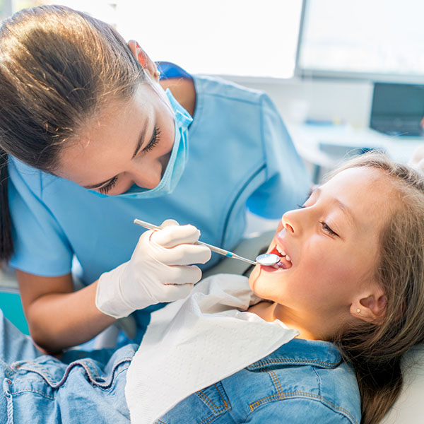 girl at the dentist getting a check up on her teeth
